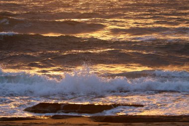 Kuzey İsrail 'de bulutlu bir gökyüzünde gün batımı. Akdeniz kıyısındaki şehrin üzerinde gün batımı. 