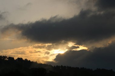 Kuzey İsrail 'de bulutlu bir gökyüzünde gün batımı. Akdeniz kıyısındaki şehrin üzerinde gün batımı. 