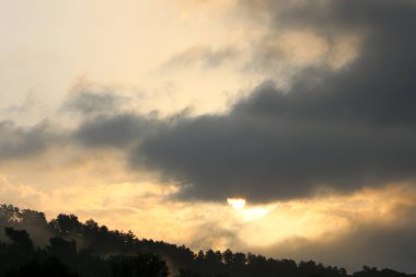 Kuzey İsrail 'de bulutlu bir gökyüzünde gün batımı. Akdeniz kıyısındaki şehrin üzerinde gün batımı. 