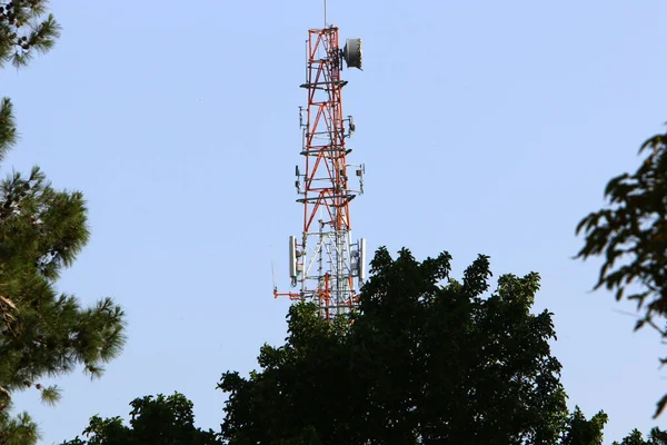 high antenna of radio and television communications against a cloudy sky in northern Israel