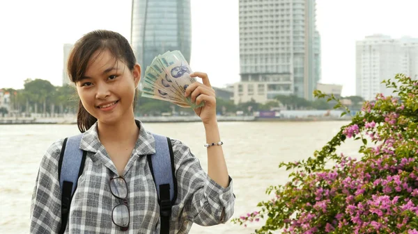 The Vietnamese girl holds in her hands and boasts five hundred thousand denominations of Vietnamese dong.