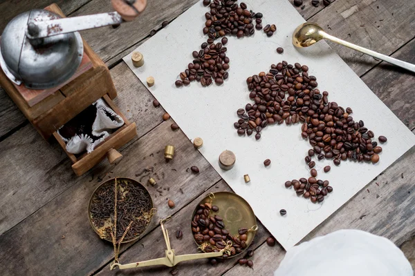 Map of the world, coffee beans on old paper. Eurasia, America, Australia, Africa. vintage. Black coffee, ground coffee, scales, old Coffee grinder on wooden background . top view. flat lay — Stock Photo, Image