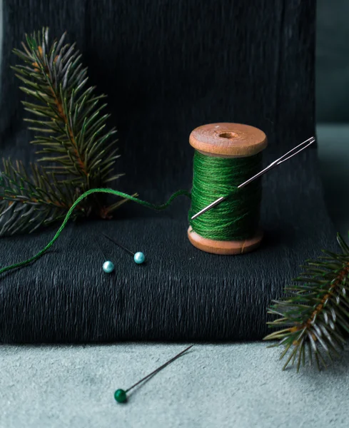 Stilleven. een oude spoel van draad met een naald, pin, tak van de zilverspar. — Stockfoto