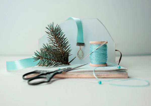 christmas, new year. preparation for the holiday - notebook, scissors, thread, silk ribbon, branch of spruce .