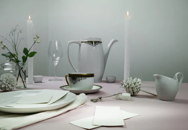 Натюрморт элегантная сервировка стола. скатерть, свечи, антикварный фарфор - чашка и блюдце, чайник — стоковое фото