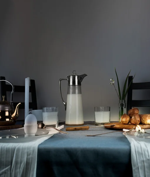 Natürmort. rustik yemek. süt kabı, mumlar, çay, yumurta, ekmek masada ekmek — Stok fotoğraf