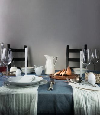 Natürmort. kabı, gözlük, topuz, mavi bir masa örtüsü üzerinde beyaz mumlar