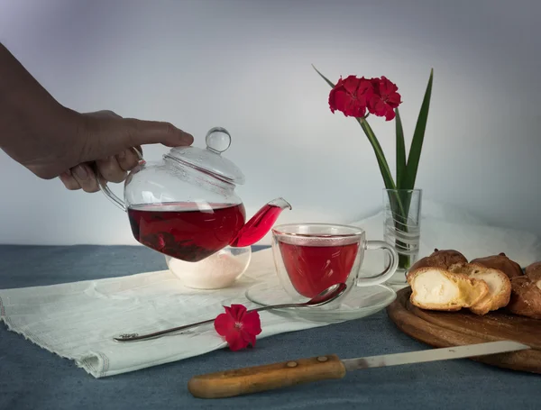 Female hand pouring tea from a teapot into glass cup — Φωτογραφία Αρχείου