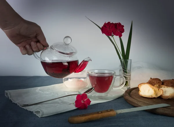 Female hand pouring tea from a teapot into glass cup — Φωτογραφία Αρχείου