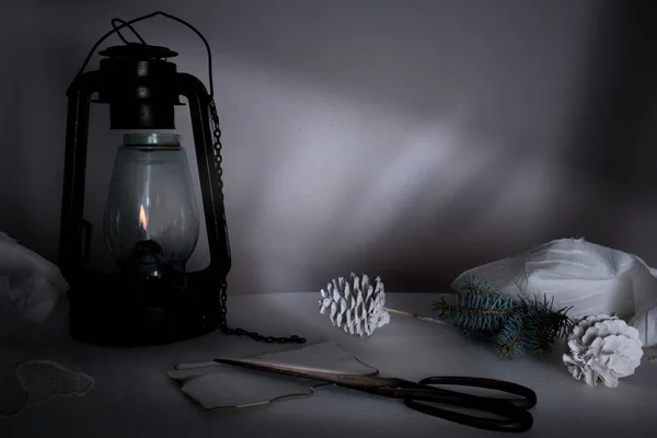 Ano Novo, Natal. lâmpada de querosene com ramos de abeto e cones em uma mesa no crepúsculo — Fotografia de Stock