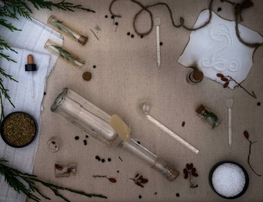 Simya Lab. kurumuş otlar, tuz, şişeler, eski tuval üzerine yemek tarifleri. Üstten Görünüm