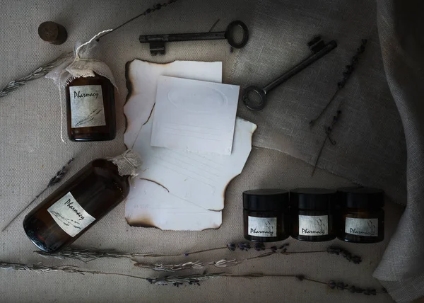 Sheets burnt paper, cans and bottles, old keys, dry lavender. view from above.