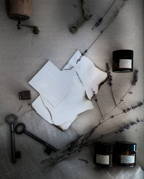 Bladen verbrand papier, blikjes en flessen, oude sleutels, droge lavendel. bovenaanzicht — Stockfoto