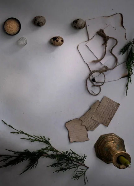 jars of powders, leaves burnt paper, candle, quail eggs on the table. top view