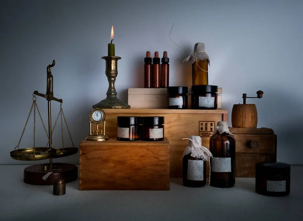 Алхимическая лаборатория. бутылки, банки, весы, свечи на деревянных полках — стоковое фото