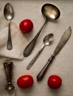 antika gümüş çatal bıçak takımı ve kiraz domates üzerine yağlıboya, üstten görünüm