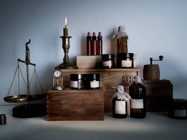 Oude apotheek. flessen, potten, schalen, kaars op houten planken — Stockfoto