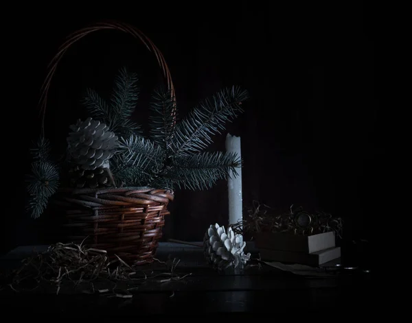 Natal, ano novo. cesta com ramos de abeto e cones em um fundo escuro . — Fotografia de Stock