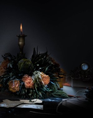Natürmort. Bronz şamdan içinde mum, turuncu buket gül, izle. gece