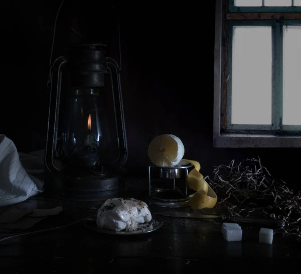 Ainda vida. Pequeno Dutch. lâmpada de querosene com limão purificado e açúcar em uma mesa de madeira contra a janela — Fotografia de Stock