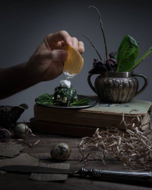 cips, ıspanak, sos, vintage kitap. el karanlık bir arka plan üzerinde mans