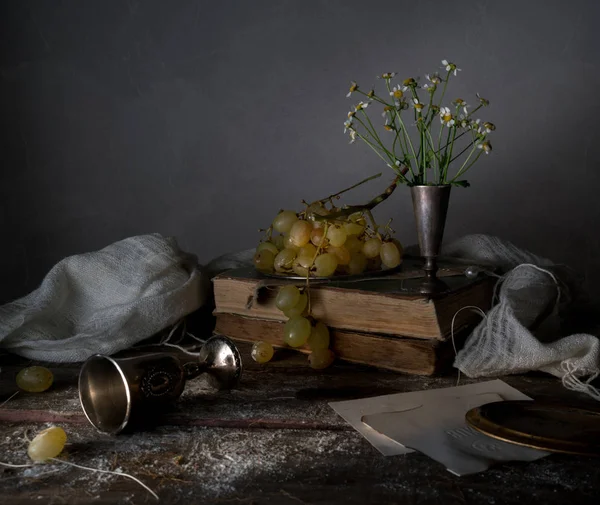 Stilleven, vintage. zilveren schotel met druiven, taart, gordijnen, een boeket van madeliefjes — Stockfoto