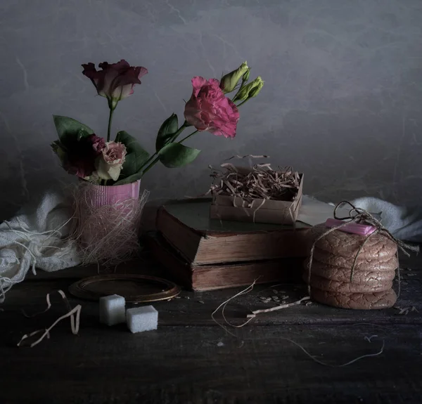 Ainda vida, vintage. livros velhos, rosa, bolos, cortinas em mesa de madeira — Fotografia de Stock