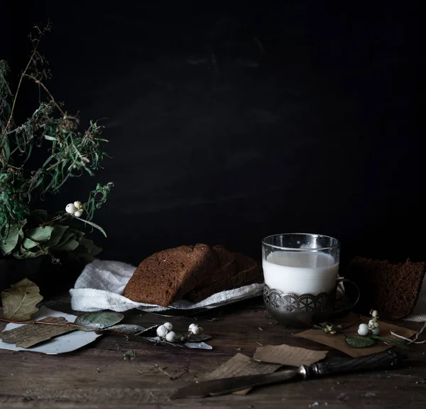 Naturaleza muerta. vintage. un sencillo desayuno campestre sobre mesa de madera. leche, pan, huevos. fondo negro — Foto de Stock