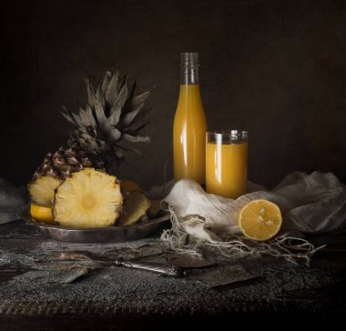 Natürmort. ananas, limon, tropikal meyve suyu, ahşap bir masa üzerinde eski gümüş bıçak