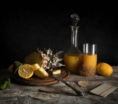 Natürmort. ananas, limon, tropikal meyve suyu, ahşap bir masa üzerinde eski gümüş bıçak