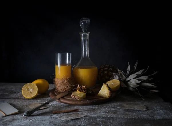 Stilleven. citroen, tropische ananassap, oude zilveren mes op een houten tafel — Stockfoto