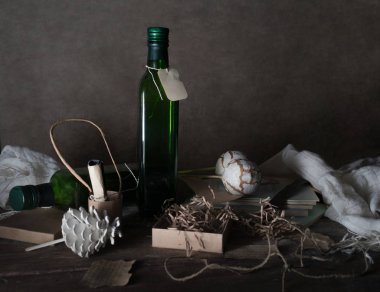 Natürmort, vintage. bir etiket, kutu, eşarp, dekor ahşap masa üzerinde şişesiyle. koyu arka plan. metin için yer