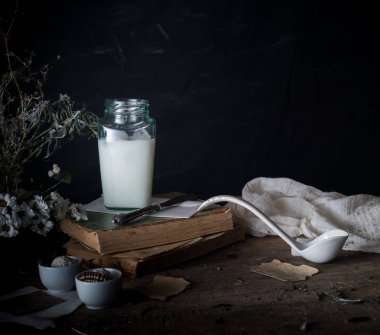 rustik kahvaltı. Natürmort, vintage. kitap krizantem, süt banka. metin için yer. siyah arka plan