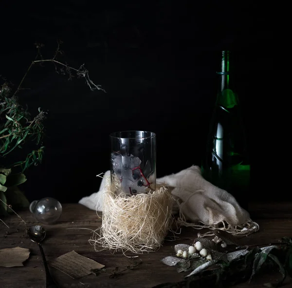 Stilleven, vintage. een glas mineraalwater en bessen, boeket op houten tafel. donkere achtergronden. . — Stockfoto