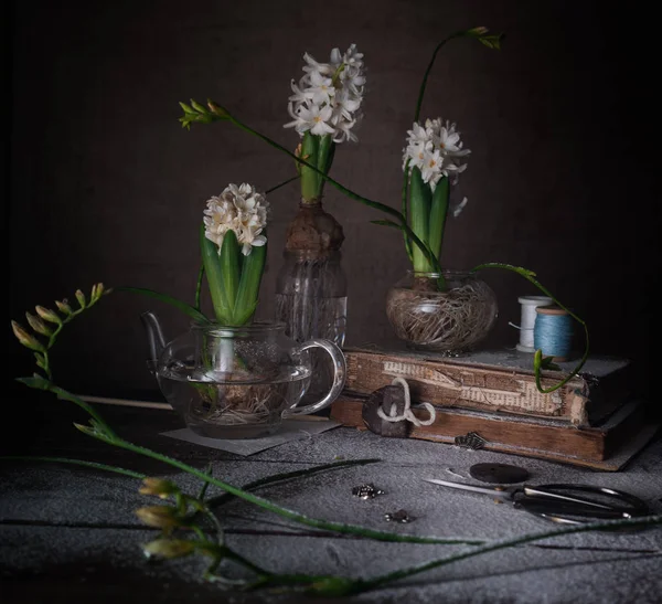 Stilleven met oude boeken, kwarteleitjes, witte hyacinten op een donkere achtergrond. — Stockfoto