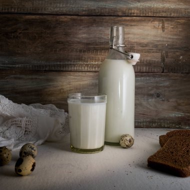 bir şişe süt, yumurta ve ekmek sert ahşap duvar arka plan üzerinde rustik natürmort