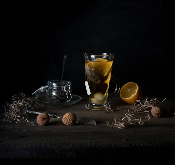 Ρουστίκ νεκρή. φλιτζάνι τσάι, λεμόνι και ορτυκιού αυγά σε ένα ξύλινο τραπέζι. μαύρο φόντο — Φωτογραφία Αρχείου