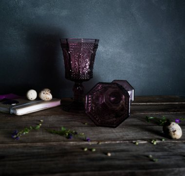 Ahşap bir masa, söğüt dalları üzerinde iki vintage gözlük. Koyu arka plan.