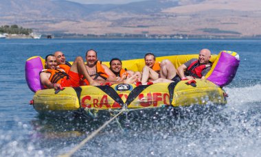 Grup genç adam şişme bir cazibe üzerinde yüzen