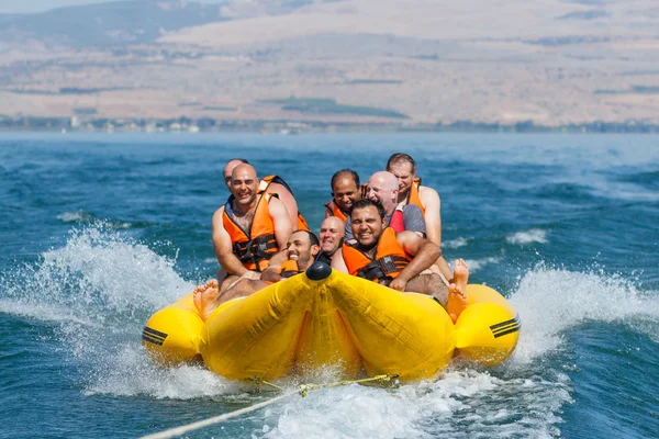 Groupe de jeunes hommes flottant sur une attraction gonflable — Photo