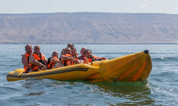 Groupe de jeunes hommes flottant sur une attraction gonflable — Photo