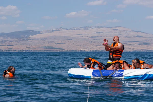 Groupe de jeunes hommes flottant sur une attraction gonflable — Photo