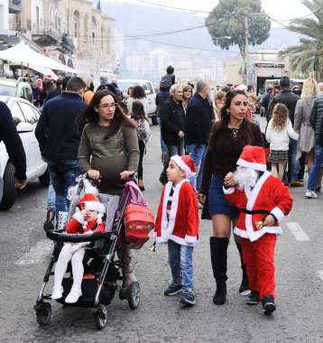 Genç anne ile küçük Noel Baba Noel pazarı üzerinde yürüme
