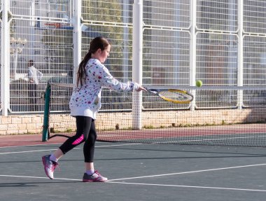 Tenis Kortu ve sayısı raket üzerinde top oynamaya kız