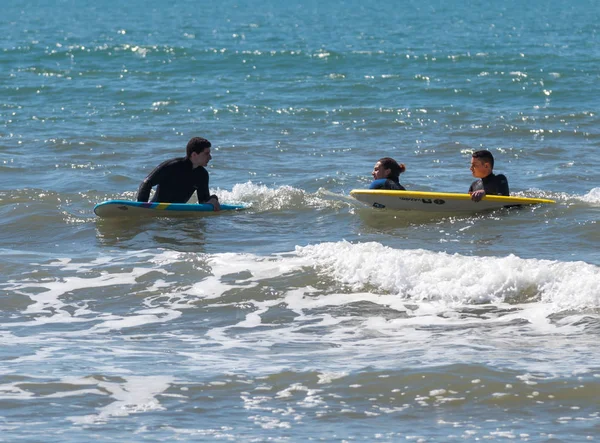 Jovens se exercitando no surf nas pranchas — Fotografia de Stock