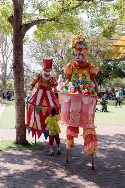 stock image Clowns on stilts greet a small visitor to attractions park