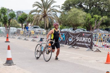 Katılımcı yıllık triatlon tamamlandıktan sonra bir bisiklet kurtulmak