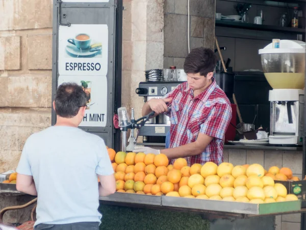 Street vendor prepares fresh juice to women customers in the old city of Jerusalem, Israel. — Stock Photo, Image