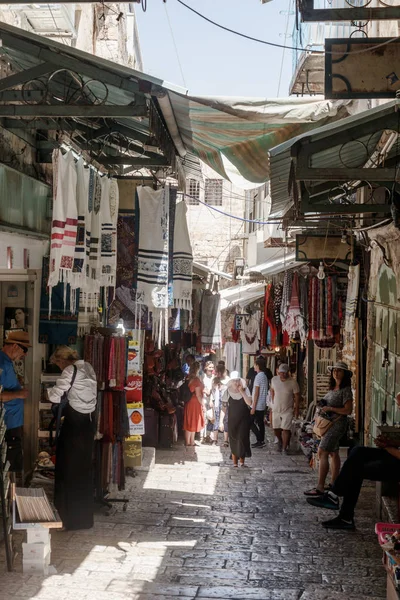 Los turistas caminan a través del bazar a lo largo de la calle David y miran los recuerdos cerca de la Puerta de Jaffa en la ciudad vieja de Jerusalén, Israel . — Foto de Stock