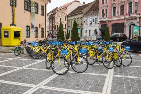 Alquiler de bicicletas de ciudad en la Plaza del Mercado del Consejo en el casco antiguo de Brasov en Rumania — Foto de Stock